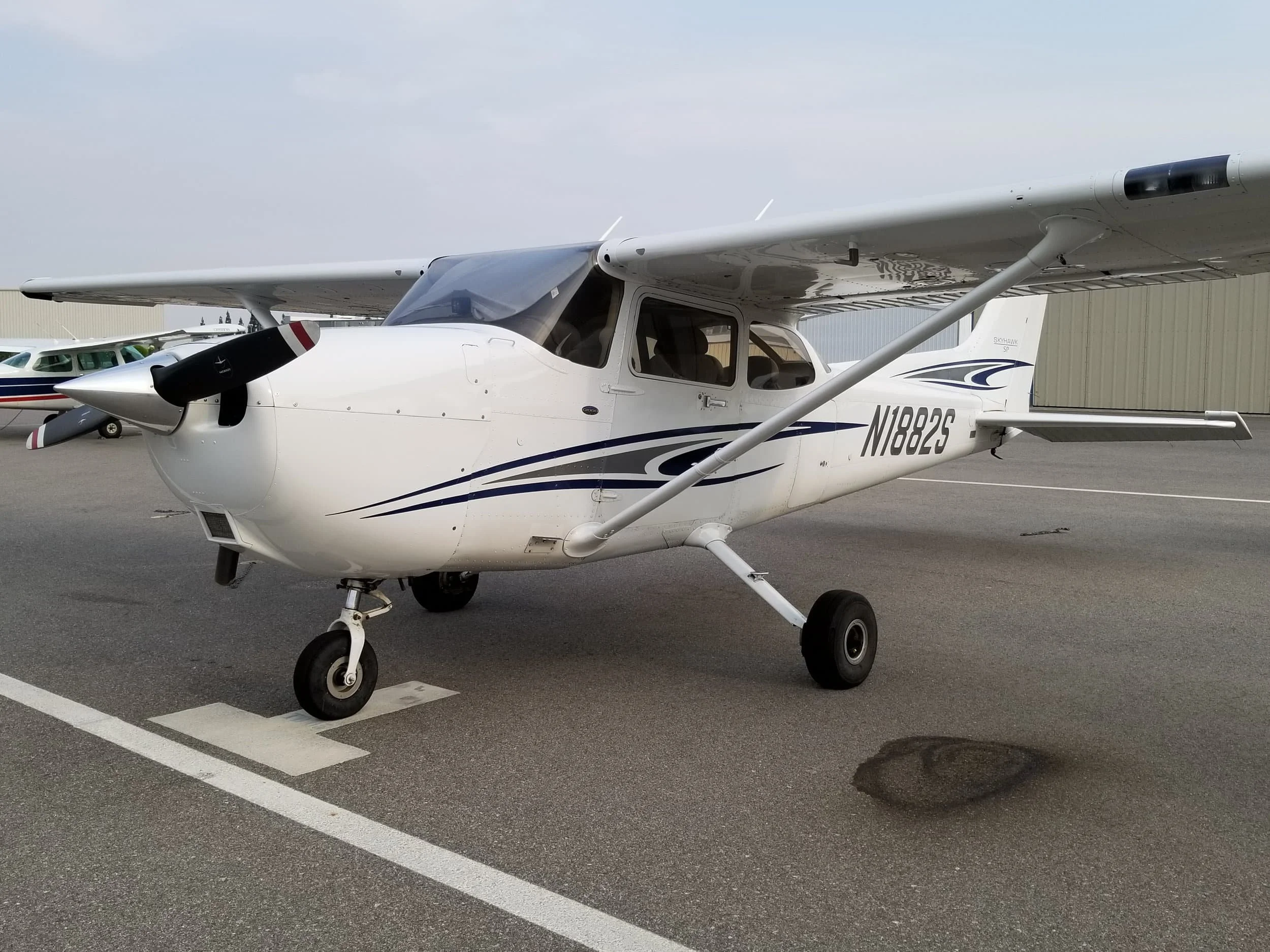 White and blue Cessna 172S training airplane on the ramp